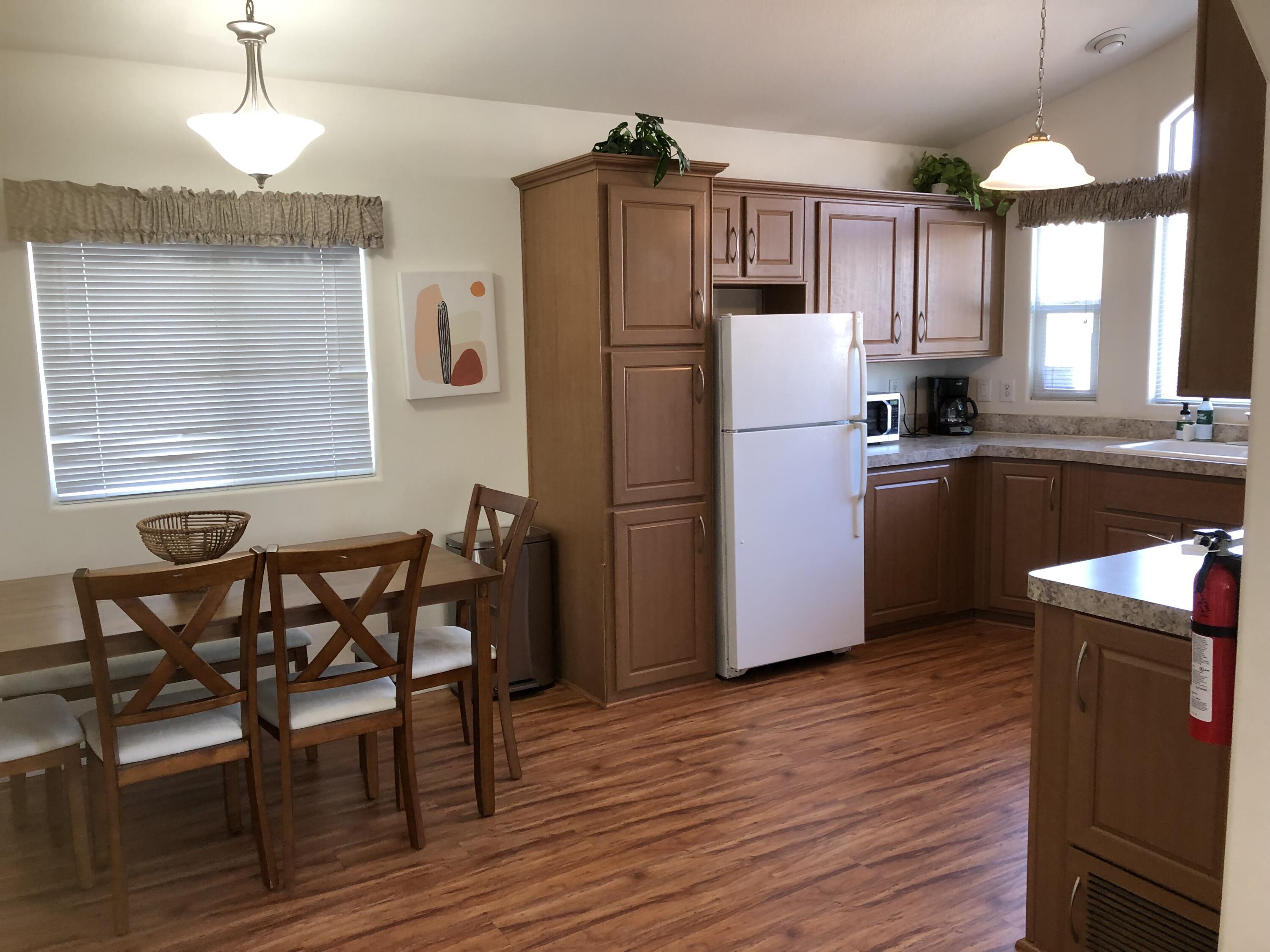 74711 Dillon Road Desert Hot Springs, CA 92241 - Photo 3 of 38 a kitchen with granite countertop stainless steel appliances a table chairs refrigerator and microwave
