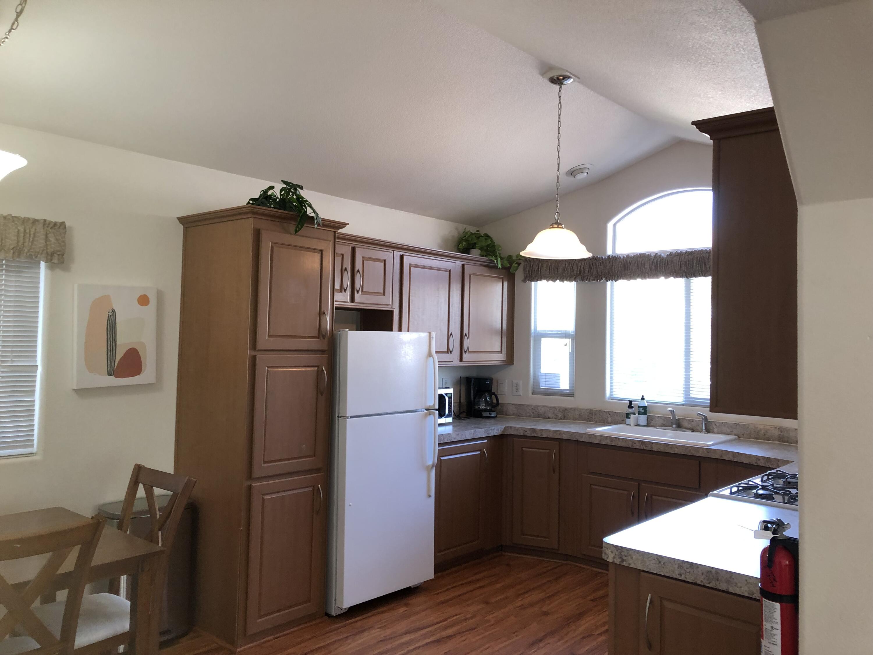 74711 Dillon Road Desert Hot Springs, CA 92241 - Photo 4 of 38 a kitchen with a refrigerator a sink and wooden floor