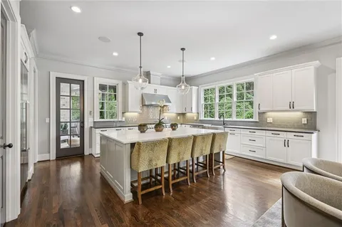 a dining room with furniture a chandelier and wooden floor