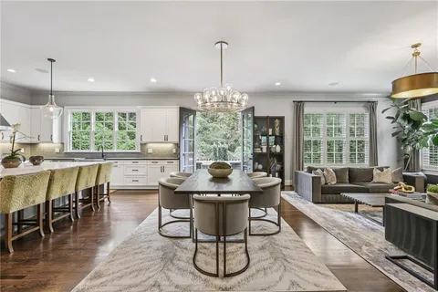 a kitchen with a stove a sink a window and chairs