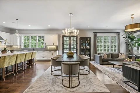 a kitchen with kitchen island a stove a counter space a sink and living room view