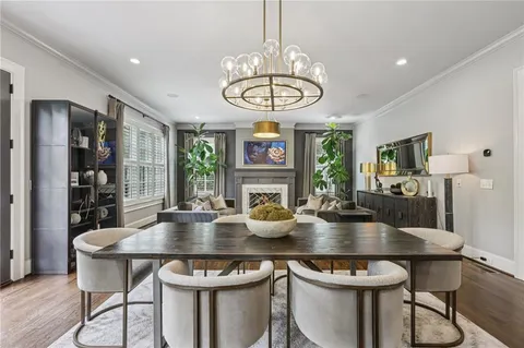 a kitchen with a stove a refrigerator a sink dishwasher a dining table and chairs with wooden floor