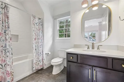 a bed sitting in a bedroom next to a window with potted plant