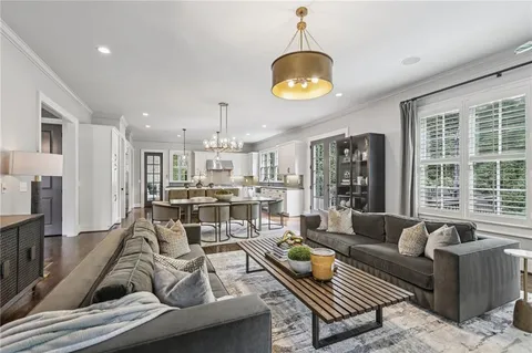 a living room with furniture chandelier and a large window