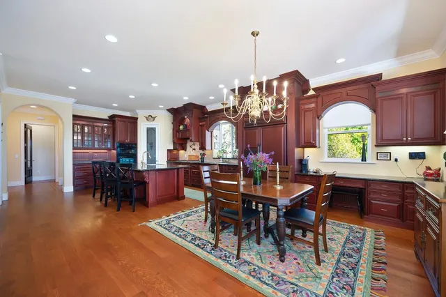 a spacious bathroom with a granite countertop double vanity sink a mirror and a bathtub