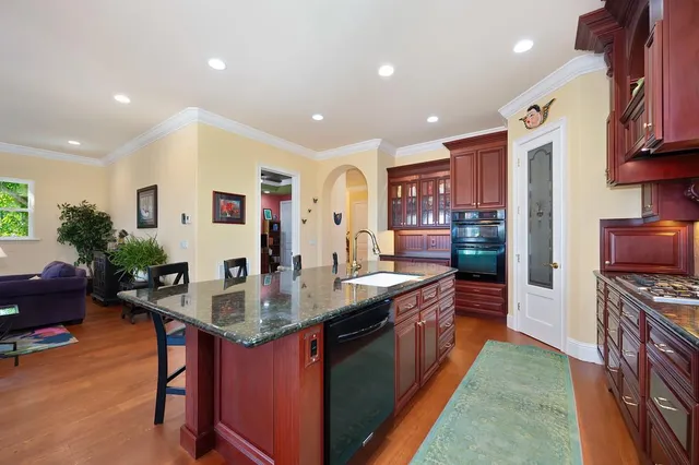 a bathroom with a granite countertop double vanity sink and mirror