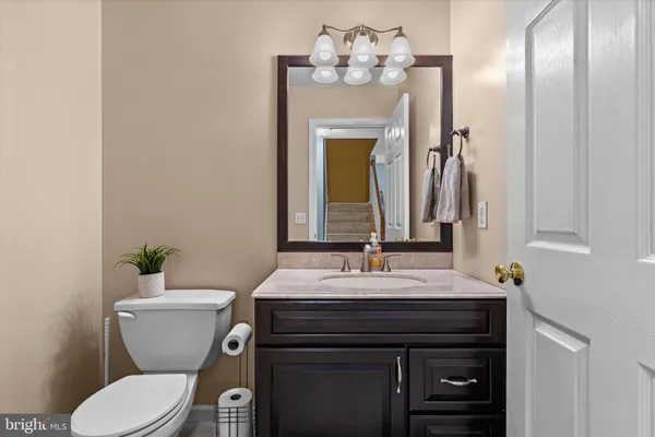 a bathroom with a sink vanity mirror and toilet