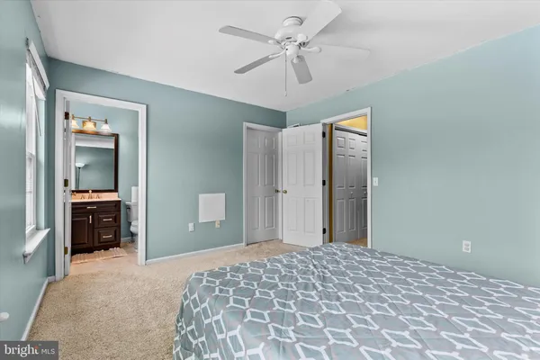 a bedroom with a bed and a chandelier fan