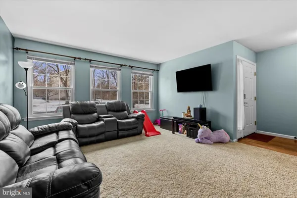 a living room with furniture a flat screen tv and a large window