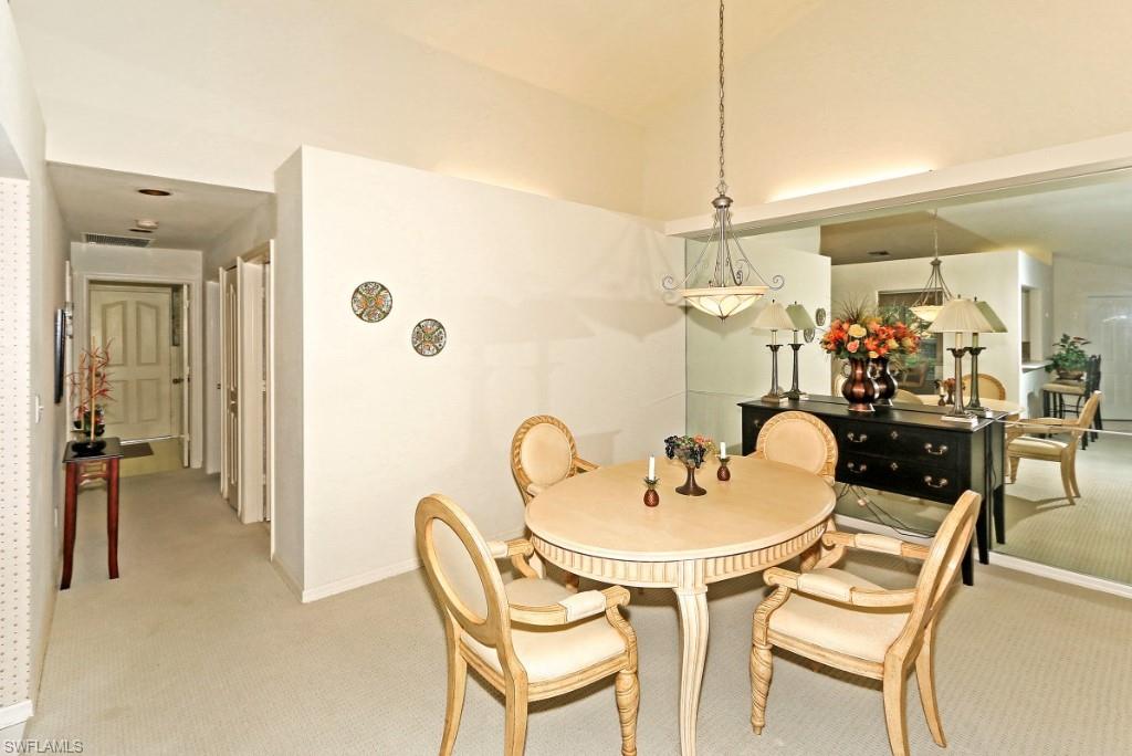 214 Napa Ridge Road East Naples, FL 34119 - Photo 3 of 12 a dining room with furniture and a chandelier