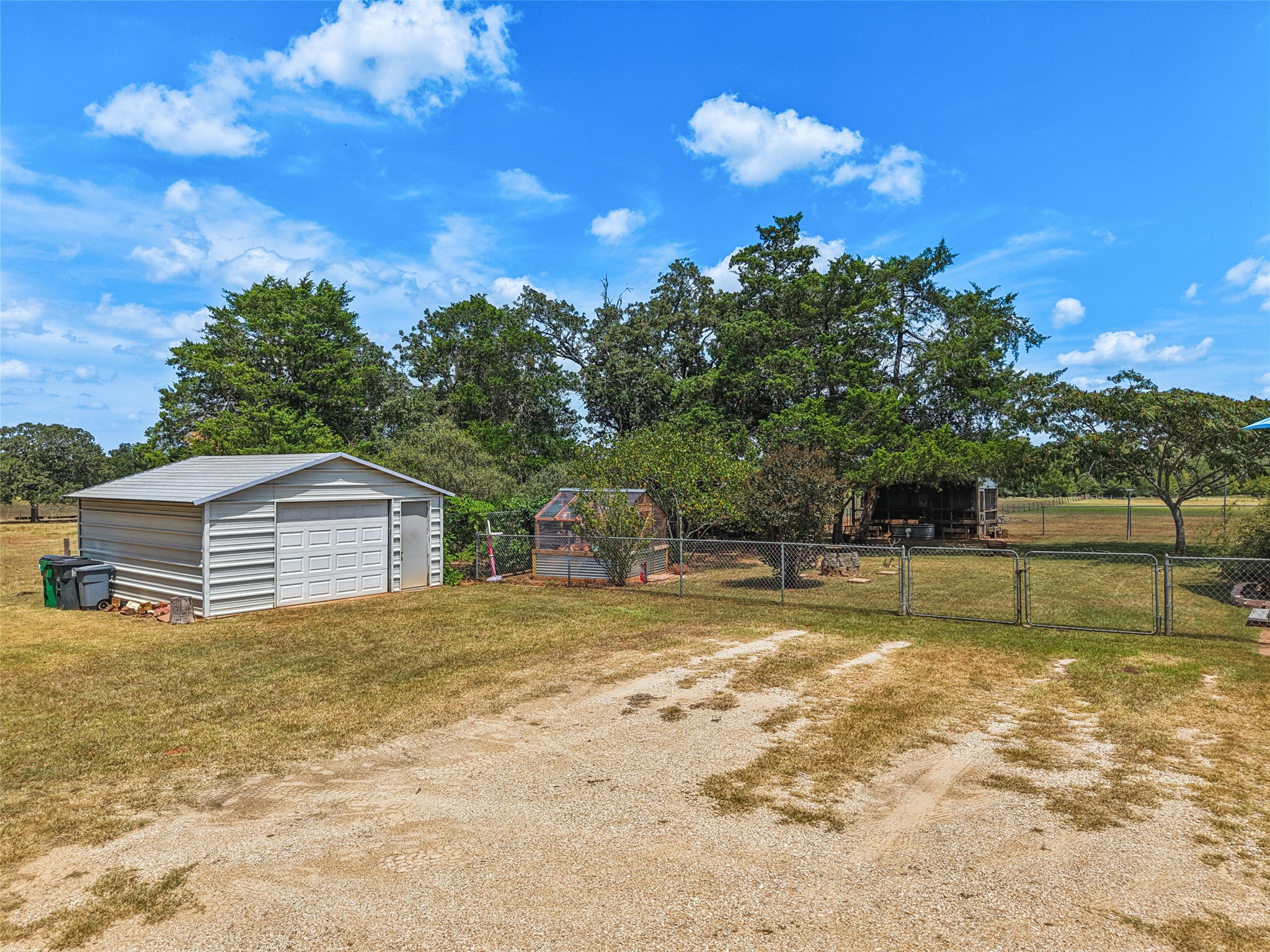 372 Hofferek Road Rosanky, TX 78953 - Photo 38 of 40 View of yard featuring a garage, an outbuilding, a gate, and driveway