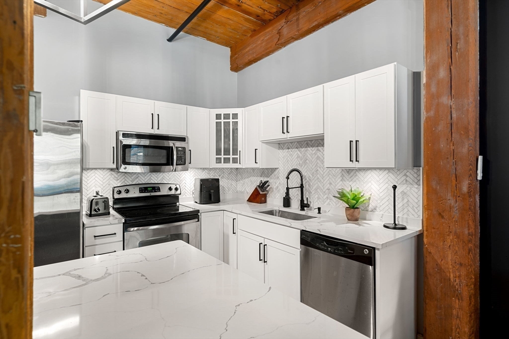 1511 Main Street, Unit B101 Worcester, MA 01603 - Photo 1 of 41 a kitchen with white cabinets and appliances