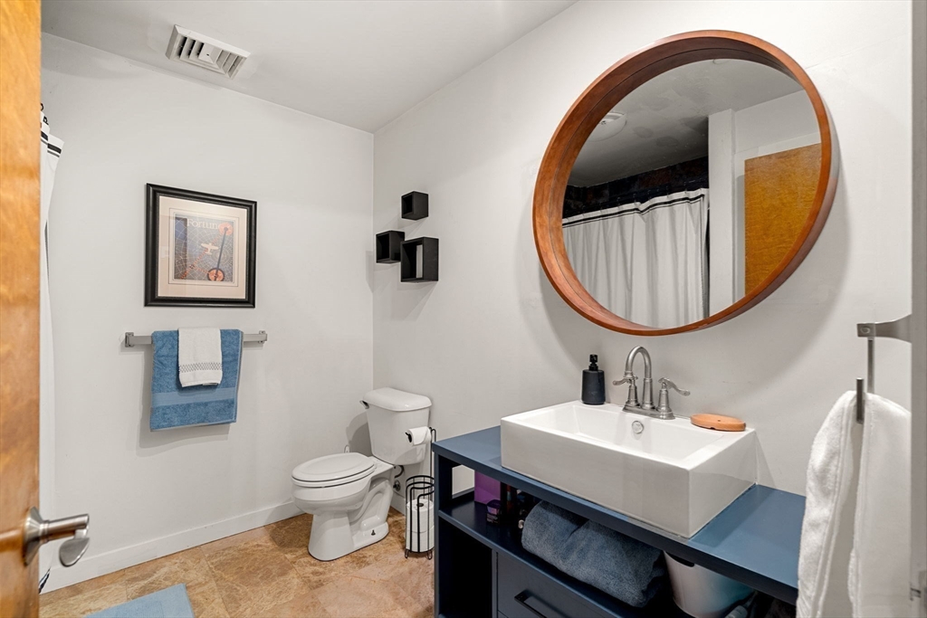 1511 Main Street, Unit B101 Worcester, MA 01603 - Photo 25 of 41 a bathroom with a toilet a sink and a mirror