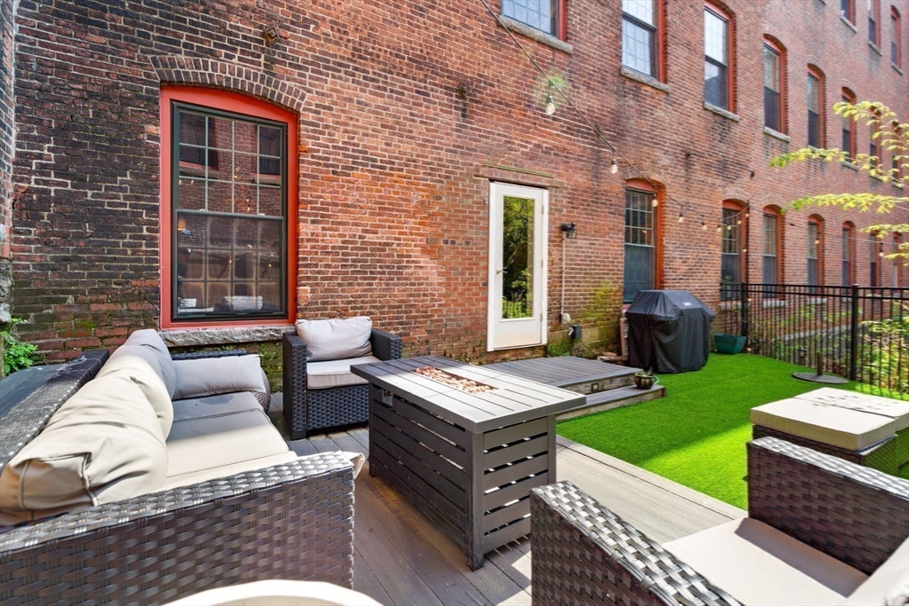 1511 Main Street, Unit B101 Worcester, MA 01603 - Photo 27 of 41 a view of a patio with couches table and chairs with plants and garden