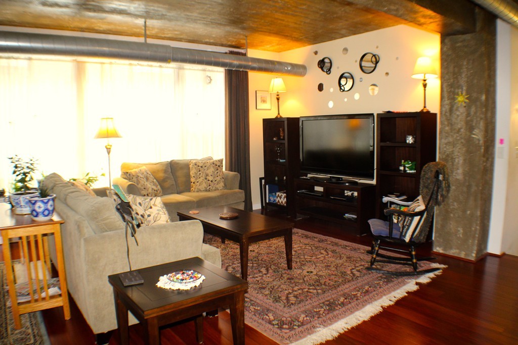 23-33 Middle Street, Unit 4 Lowell, MA 01852 - Photo 3 of 5 a living room with table chairs and a flat screen tv