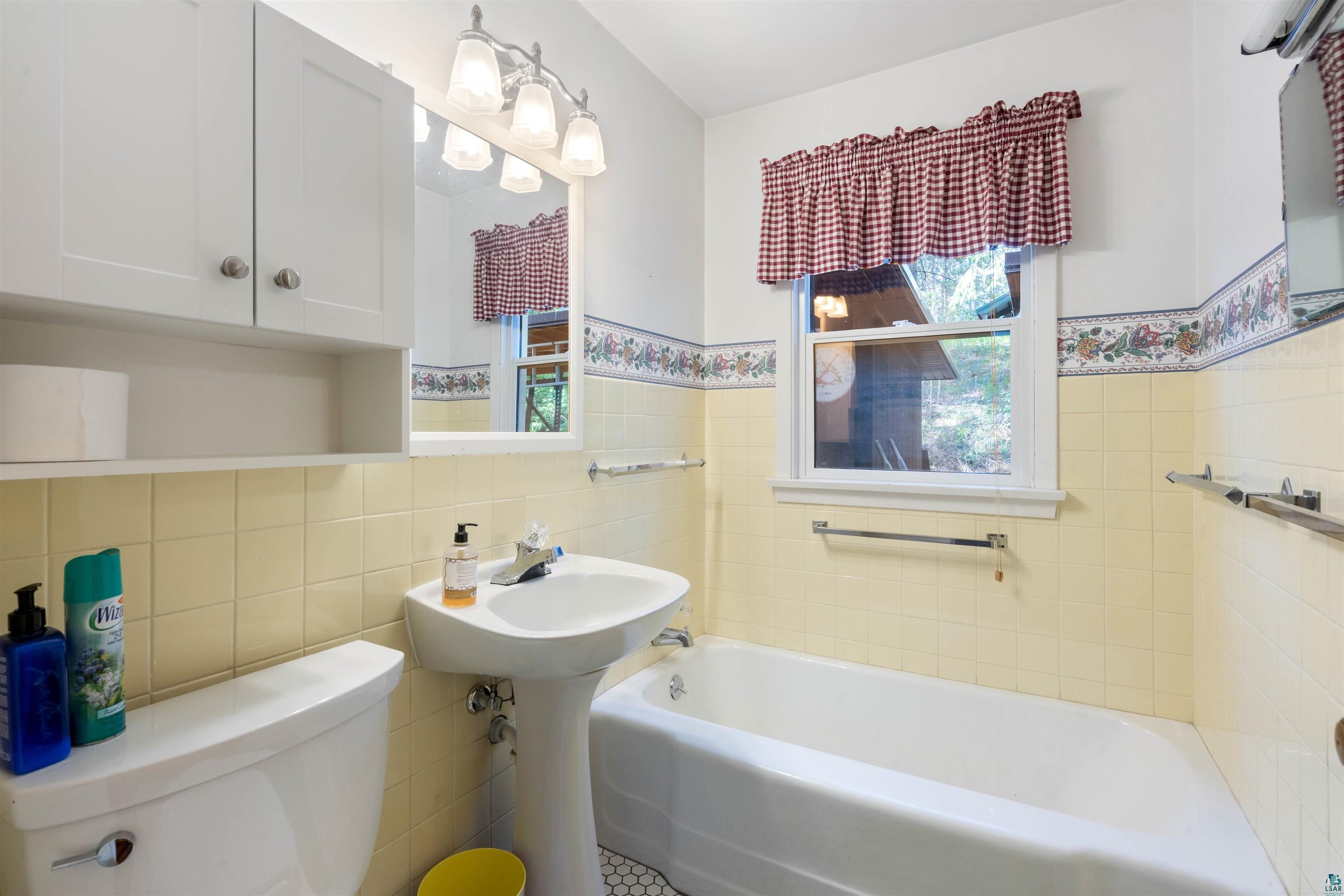 4793 Anderson Road Hermantown, MN 55811 - Photo 17 of 39 Bathroom featuring a pedestal sink, white cabinetry, and a bathtub