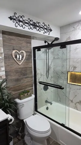 a bathroom with a toilet a sink and shower