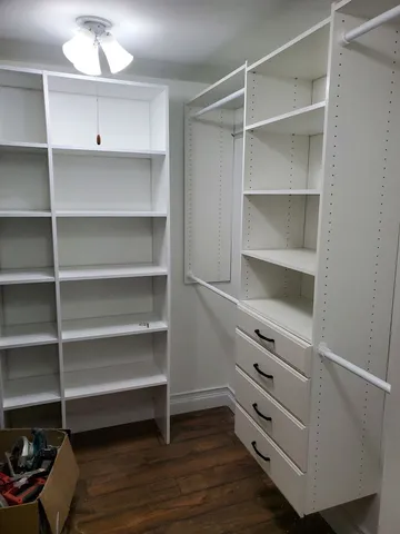 a view of walk in closet with empty racks
