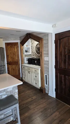 a kitchen with a stove and a wooden floor