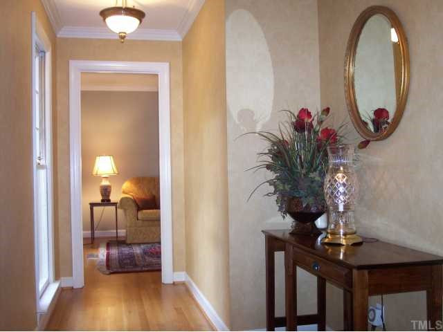 11805 Old Creedmoor Road Raleigh, NC 27613 - Photo 2 of 12 Elegant Foyer Entrance with Architectural Light Fixtures, Solid Oak Hardwood Flooring, Designer Wallpaper, and Crown Molding. Foyer