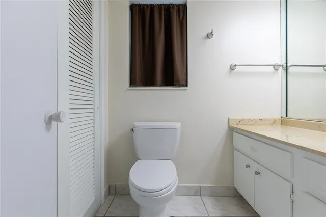 a bathroom with a granite countertop toilet sink and mirror