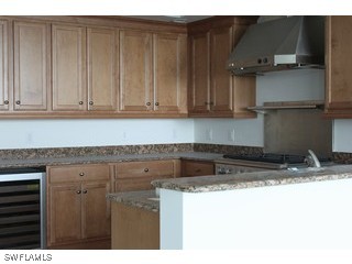 275 Indies Way, Unit 1603 Naples, FL 34110 - Photo 4 of 5 a kitchen with a sink a refrigerator and cabinets