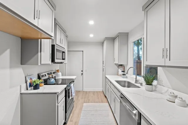 a kitchen with a sink stove and cabinets