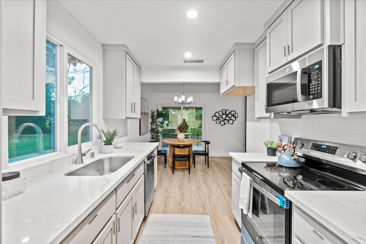 6637 Briartree Way Citrus Heights, CA 95621 - Photo 10 of 23 a kitchen with stainless steel appliances granite countertop a sink dishwasher stove and microwave with wooden floor