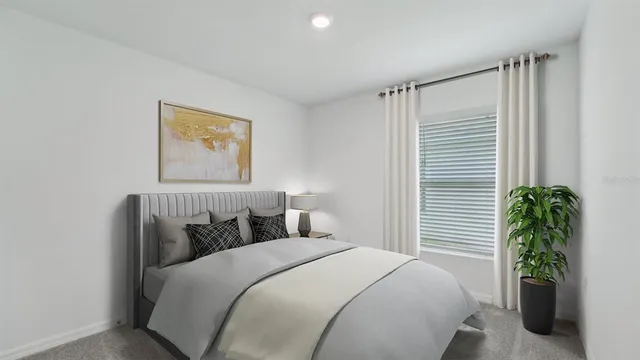 a bedroom with a bed and a potted plant