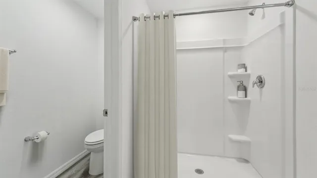 a bathroom with a shower a toilet and sink