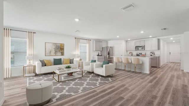 a living room with furniture and view of kitchen