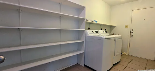 a utility room with cabinets washer and dryer