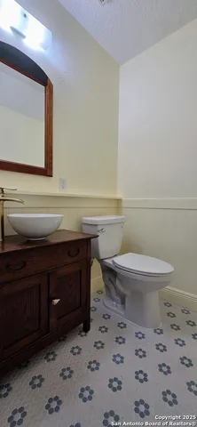 a bathroom with a toilet a sink and mirror