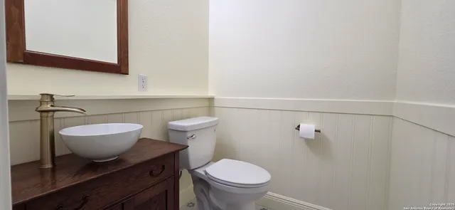 a bathroom with a toilet a sink and mirror