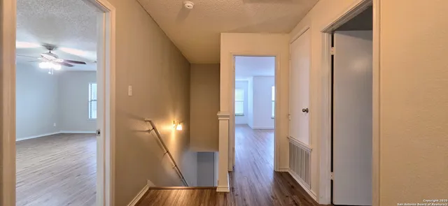 a view of a hallway with wooden floor