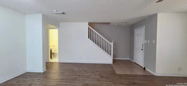 a view of hallway with wooden floor and stairs