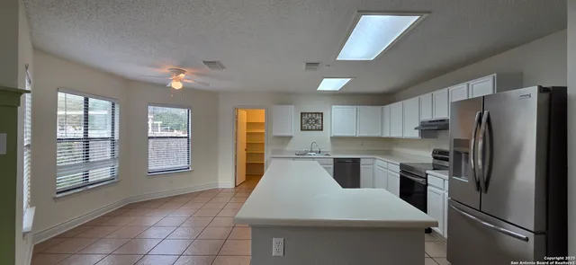 a kitchen with a refrigerator sink and cabinets