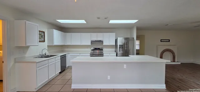 a kitchen with stainless steel appliances a sink stove and refrigerator