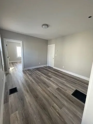 a view of an empty room and wooden floor