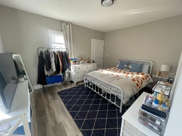 a bedroom with a bed and wooden floor