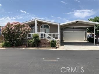 21650 Temescal Canyon Road, Unit 13 Corona, CA 92883 - Photo 1 of 21 a front view of a house with a yard and garage