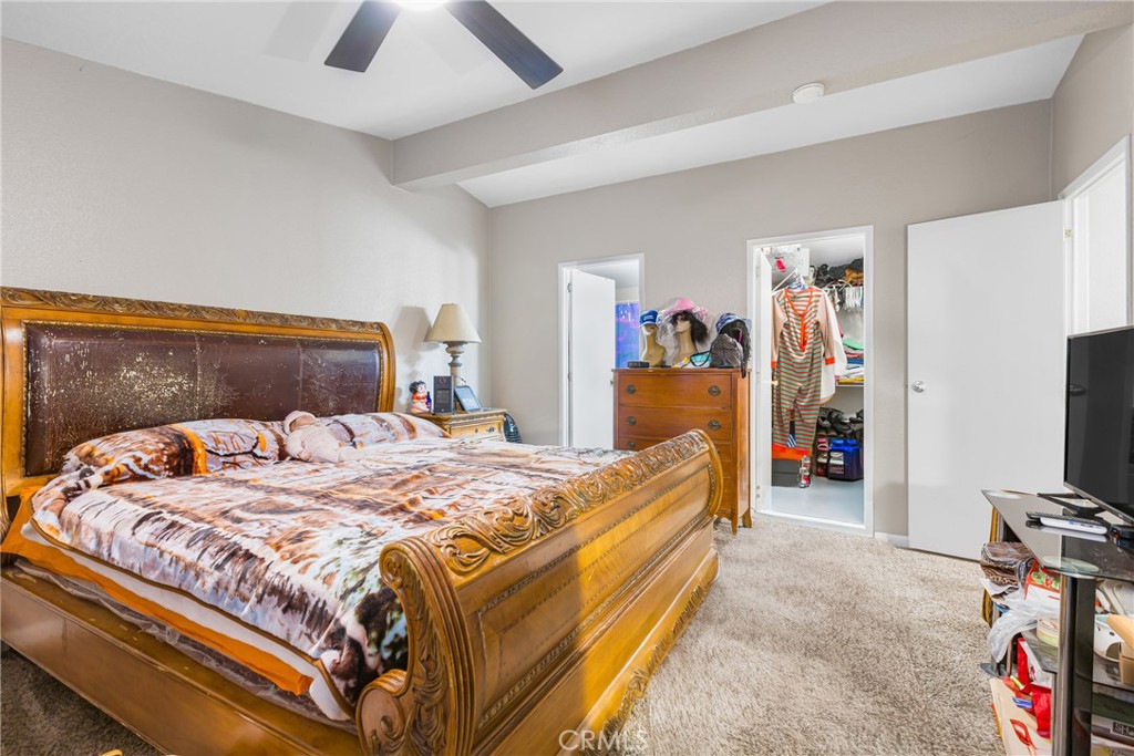 21650 Temescal Canyon Road, Unit 13 Corona, CA 92883 - Photo 11 of 21 a bed sitting in a bedroom and a flat tv screen