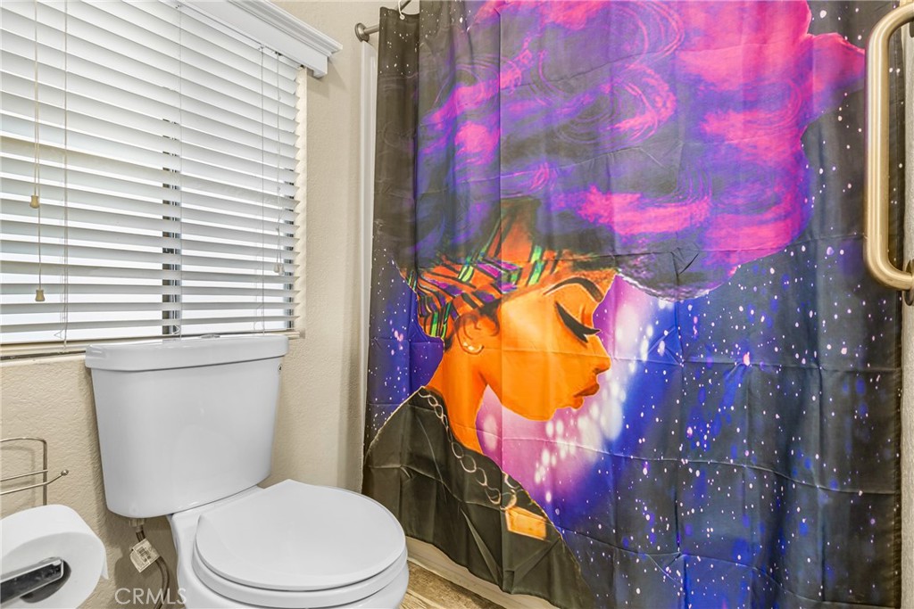 21650 Temescal Canyon Road, Unit 13 Corona, CA 92883 - Photo 14 of 21 a bathroom with a toilet sink and mirror