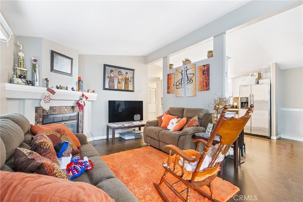 21650 Temescal Canyon Road, Unit 13 Corona, CA 92883 - Photo 8 of 21 a living room with furniture a fireplace and a flat screen tv