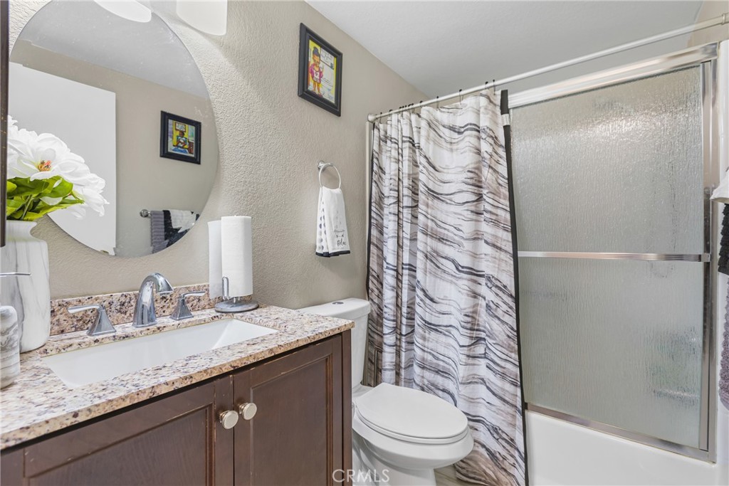 21650 Temescal Canyon Road, Unit 13 Corona, CA 92883 - Photo 10 of 21 a bathroom with a granite countertop sink toilet and shower
