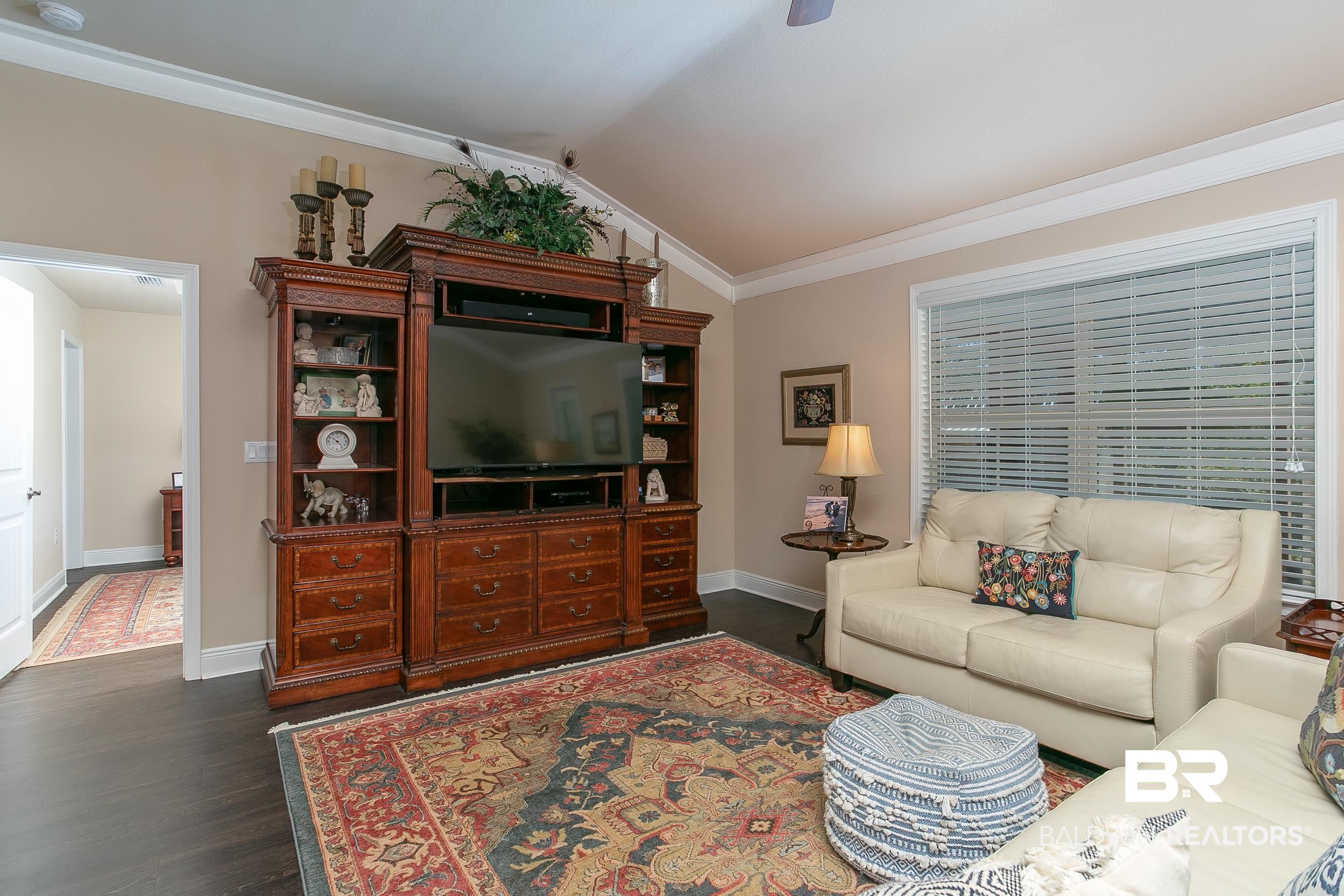 13154 Vincent Court Foley, AL 36535 - Photo 10 of 41 Living area with baseboards, crown molding, lofted ceiling, and dark wood finished floors