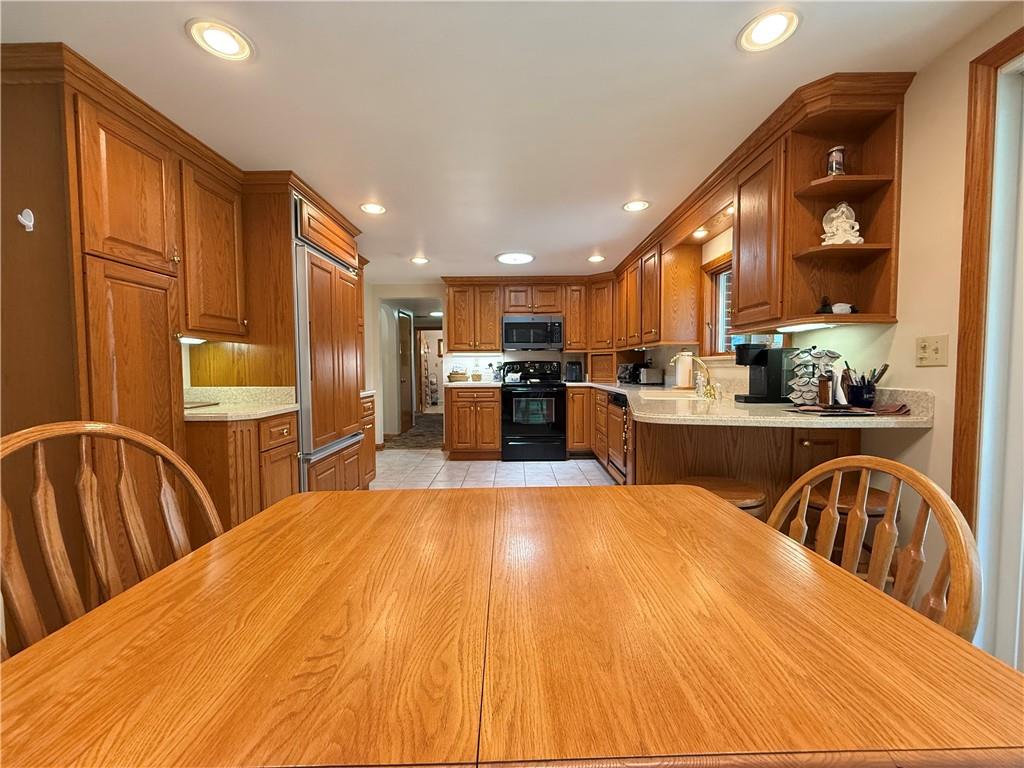 325 Williamson Road Greenville, PA 16125 - Photo 17 of 50 a large kitchen with stainless steel appliances kitchen island granite countertop a refrigerator a stove a sink dishwasher with a dining table and chairs