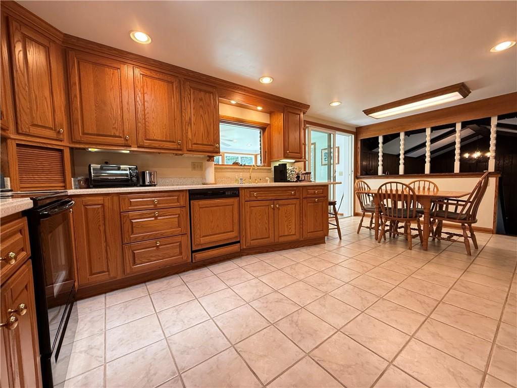 325 Williamson Road Greenville, PA 16125 - Photo 19 of 50 a large kitchen with stainless steel appliances granite countertop a stove a sink a dining table and chairs