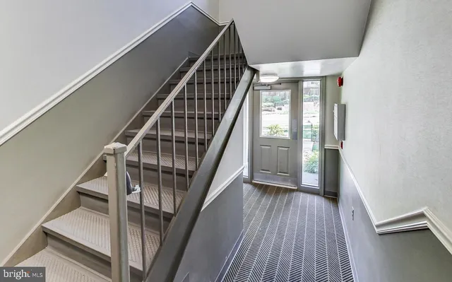 a view of staircase with wooden floor and white walls