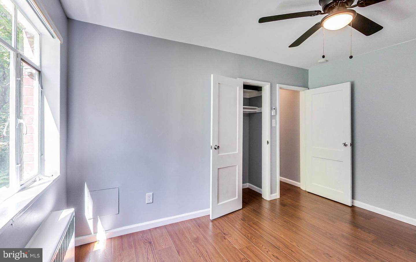 10301 Montrose Avenue, Unit 101 Bethesda, MD 20814 - Photo 10 of 27 an empty room with wooden floor chandelier fan and windows